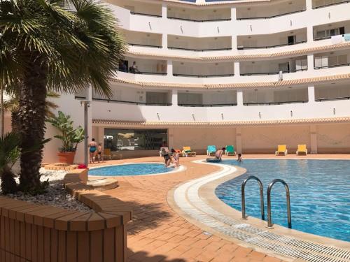 珀彻斯Clube Nautilus的酒店游泳池的背景是一座大型建筑