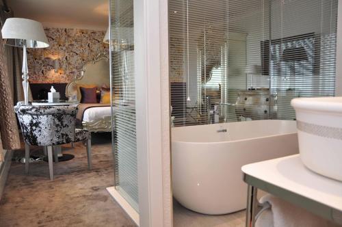 班夫班芙泉酒店的一间带浴缸和水槽的浴室以及一间卧室