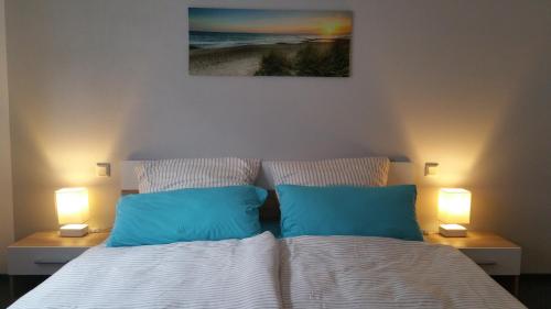 TholeyFerienwohnung Auszeit的卧室内的一张带两个蓝色枕头的床