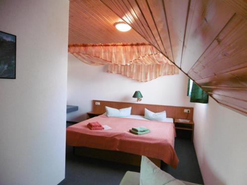 HochkirchHotel & Pension Aßmann的一间卧室配有一张红色棉被的床