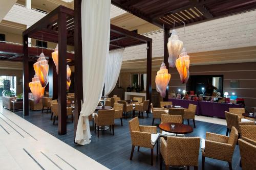 厄尔梅达诺Kn Hotel Arenas del Mar Adults Only的一间带桌椅的餐厅和一间酒吧