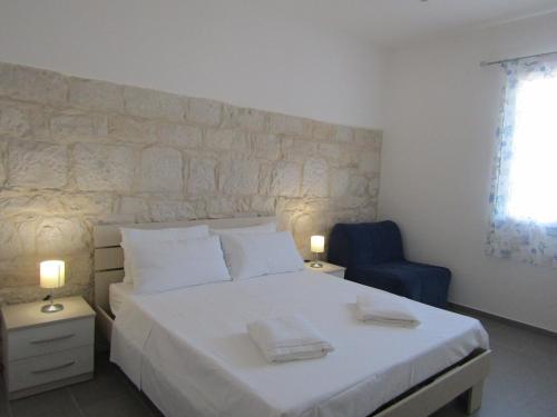 拉古萨码头Blu Maris Sicilia Guesthouse的卧室配有白色的床和蓝色椅子