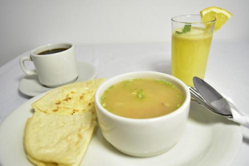 OcañaHotel El Principe的盘子里的汤,配上玉米饼和饮料