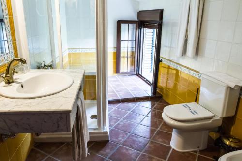 加拉罗萨Aparthotel Rural 12 Caños的一间带水槽、卫生间和淋浴的浴室