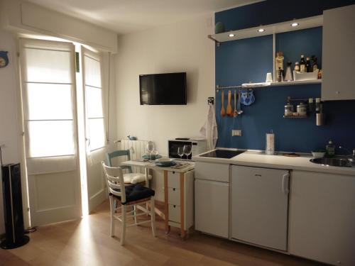 乌迪内Ichnussa的厨房拥有蓝色的墙壁,配有桌椅
