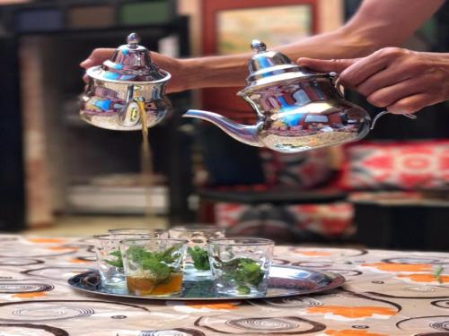 马拉喀什卡斯巴红堡旅舍的一个人在桌子上用茶壶