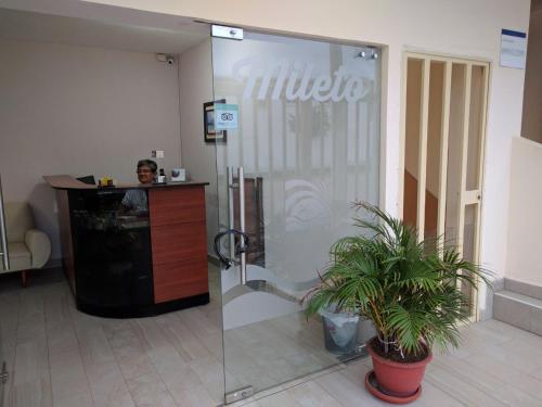 萨利纳斯Hotel Mileto的一个人站在大厅的玻璃门后面