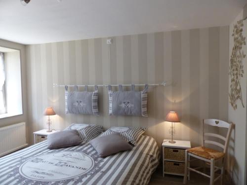 Verneuil-en-BourbonnaisLa Maison aux Hortensias的一间卧室配有一张床、两盏灯和一把椅子