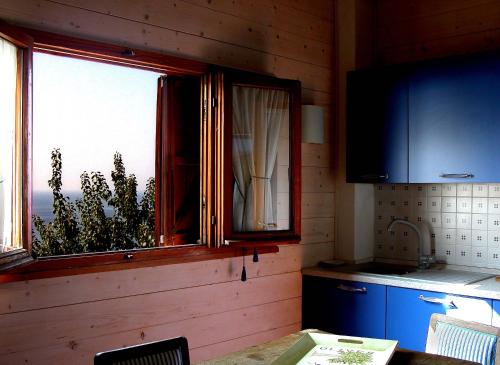 塞勒里古纳塔迪蒙特泰伯乡村民宿的厨房设有窗户、桌子和柜台