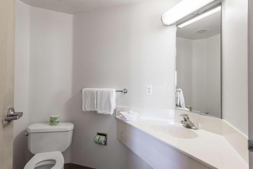 雪松城锡达城6号汽车旅馆的一间带水槽、卫生间和镜子的浴室