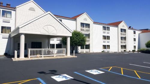 马里兰高地Motel 6-Maryland Heights, MO的一座白色的大建筑,前面设有停车场