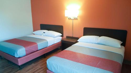 马里兰高地Motel 6-Maryland Heights, MO的酒店客房,配有两张带彩色床单的床