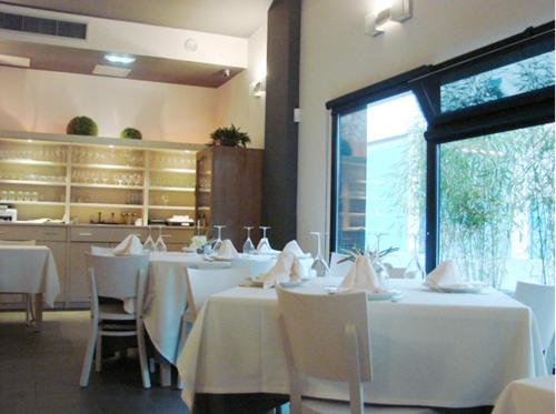 Zaldivia泽拉餐厅酒店的用餐室配有白色的桌子和白色的椅子