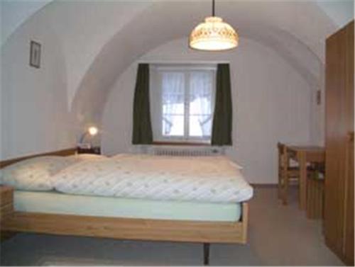 迈恩费尔德兰德加斯托圣卢奇斯哥宾馆的一间卧室配有一张带窗户和桌子的床