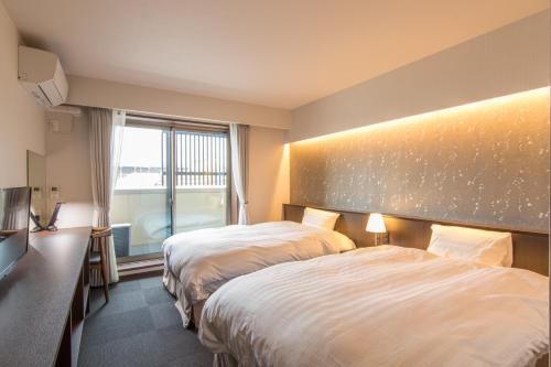 京都烏丸六条酒店的酒店客房设有两张床和窗户。