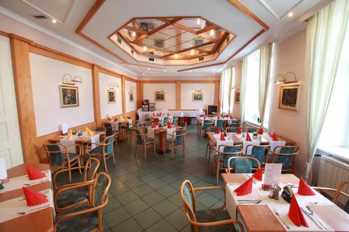 兹诺伊莫影院酒店的餐厅配有桌椅和红色餐巾