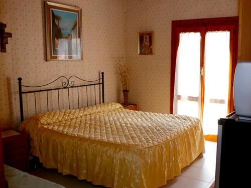 特拉蒙蒂Cantina del Casale的一间卧室配有一张带黄色床罩的床和窗户