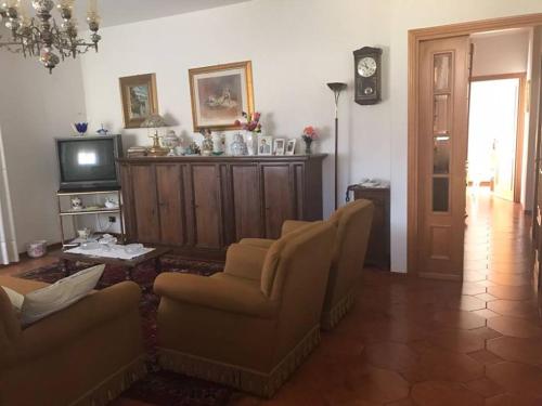 拉泰里纳Villa Marina Big的客厅配有两把椅子和电视