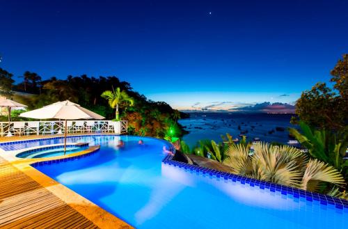 莫罗圣保罗Passárgada Pousada e Restaurante的游泳池,晚上可欣赏到海景