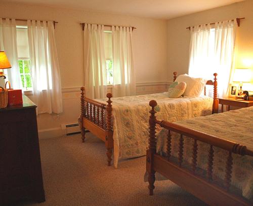 CamptonColonel Spencer Inn的一间卧室设有两张床和两个窗户。