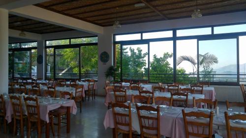 佩多拉斯双花酒店的用餐室设有桌椅和窗户。