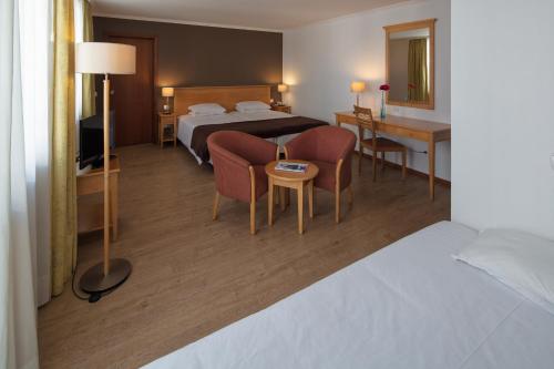 丰沙尔奥尔葵迪亚酒店的酒店客房带一张床、一张桌子和椅子