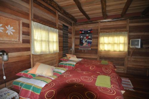 BaezaKopal的小木屋内一间卧室,配有两张床