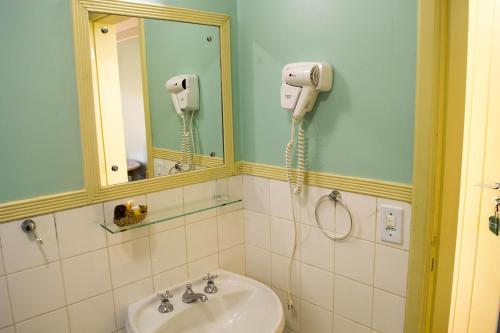 坎波斯杜若尔当波萨达维拉达斯克里斯酒店的一间带水槽的浴室和墙上的一部电话