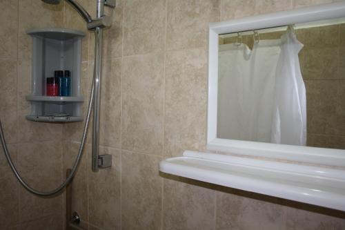 纳哈里亚嘉腾汽车旅馆的带淋浴、窗户和水槽的浴室