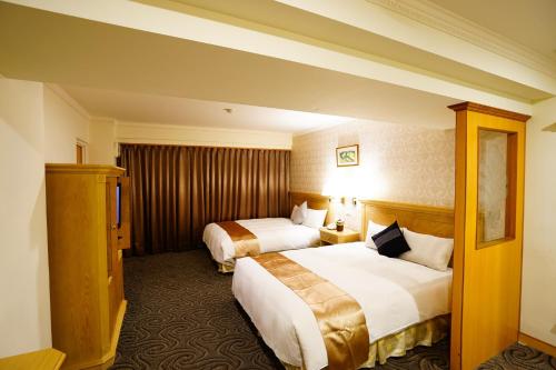 台南台南剑桥大饭店的酒店客房设有两张床和电视。