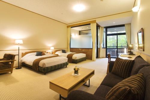高山Nakao Kogen Hotel Kazaguruma的酒店客房,设有两张床和一张沙发