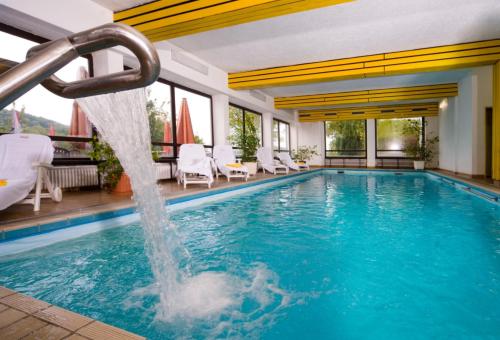 Thurmansbang舒尔格活力保健酒店的一个带水滑梯的游泳池