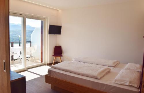卡尔达罗Hotel Tannhof的一间卧室设有一张床和一个大窗户