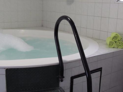 马德普拉塔圣雷莫格兰德酒店的浴室设有装满蓝色水的浴缸。