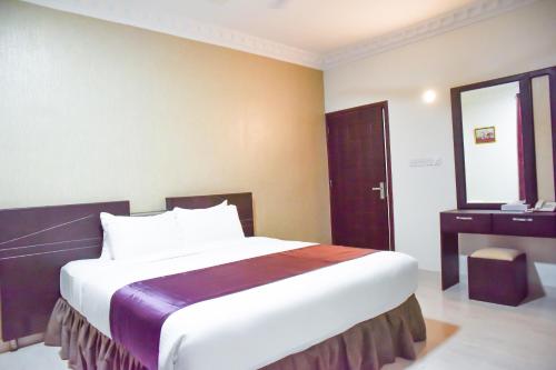 塞拉莱Gateway Salalah Apartments的酒店客房设有一张大床和一张书桌。