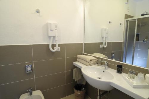 奥尔比亚安布罗休拉科尔特酒店的一间带水槽、镜子和卫生间的浴室