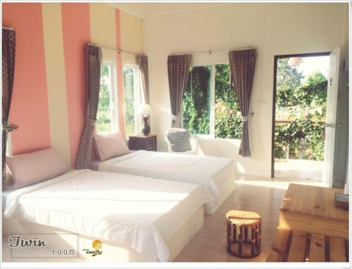 呵叻索丰花园旅馆的一间卧室设有两张床、一张桌子和窗户。