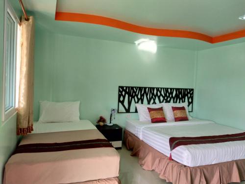 皮皮岛皮皮岛珊瑚湾旅馆的蓝色墙壁客房的两张床