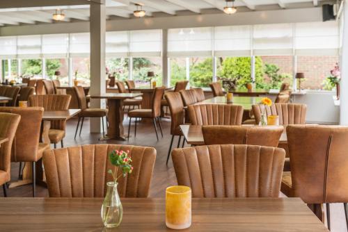 温特斯韦克Hotel Restaurant Mondriaan的餐厅设有桌椅和窗户。
