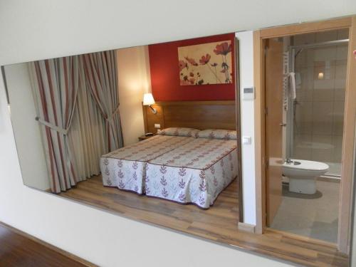 米拉格罗斯米拉格罗斯力拓里亚萨酒店的一间卧室配有一张床,浴室设有卫生间