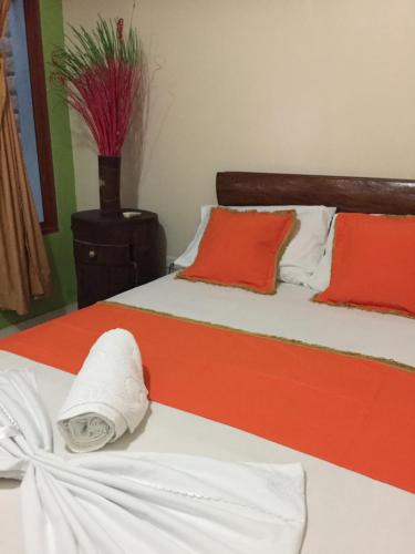 莱蒂西亚ApartaHotel Tierras Amazonicas的一间卧室配有两张红色和白色床单