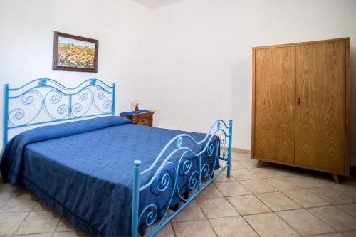 莱乌卡Pietra del Mediterraneo的一间卧室配有蓝色的床和木制橱柜