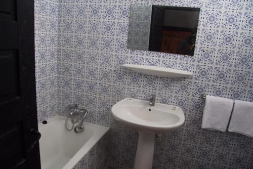 盖尼特拉Assam Hotel的一间带水槽和镜子的浴室