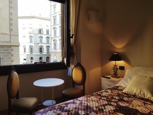 佛罗伦萨卢娜女士住宿加早餐旅馆的一间卧室配有一张床、一张桌子和一个窗户。
