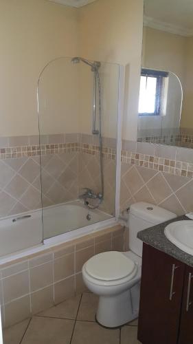 爱德华港Ocean View Villas C11的浴室配有卫生间、浴缸和水槽。