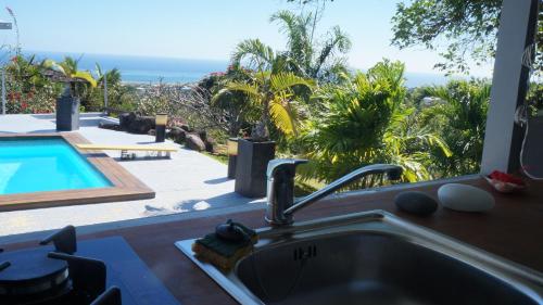 普纳奥亚Bungalow Premium Tahiti的享有游泳池景致的厨房水槽