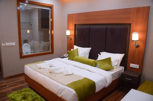 古尔冈Platinum Palace的一间卧室配有一张大床和毛巾
