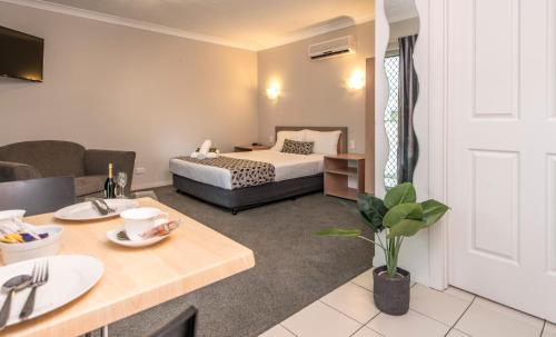 黄金海岸太平洋海岸汽车旅馆的酒店客房配有一张床铺和一张桌子。
