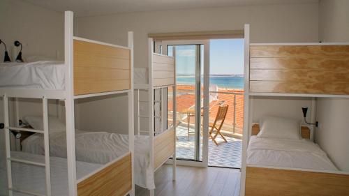拉戈斯Topcity Hostel & Suites的一间带双层床的卧室,享有海景
