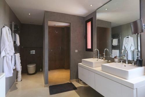 马拉喀什Villa Riad Al Maaden的一间带两个盥洗盆和大镜子的浴室